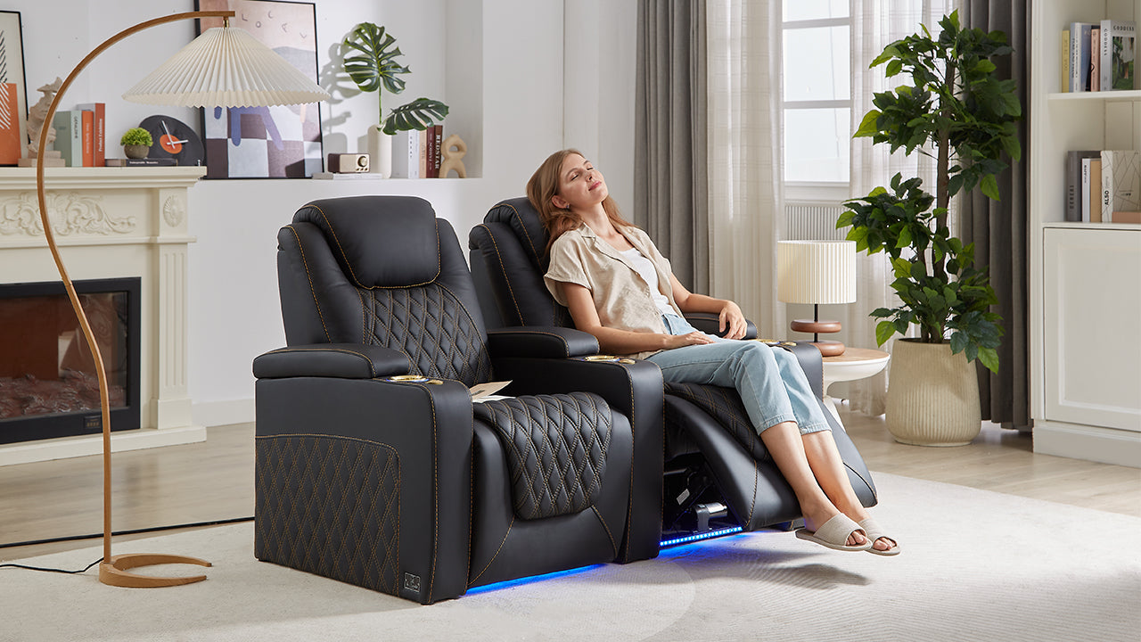 Woman relaxing in a black leather recliner with diamond stitching and ambient lighting